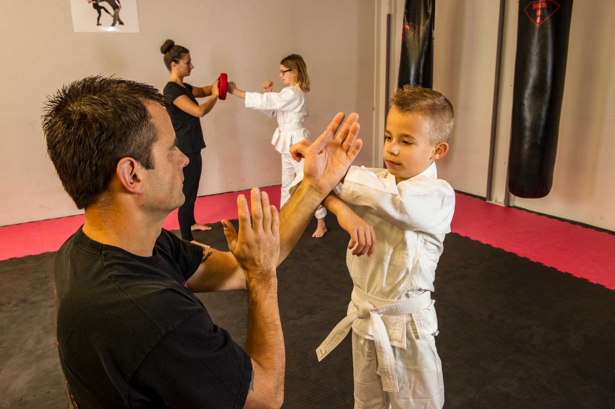 Een kind oefent een Kung Fu techniek met begeleiding