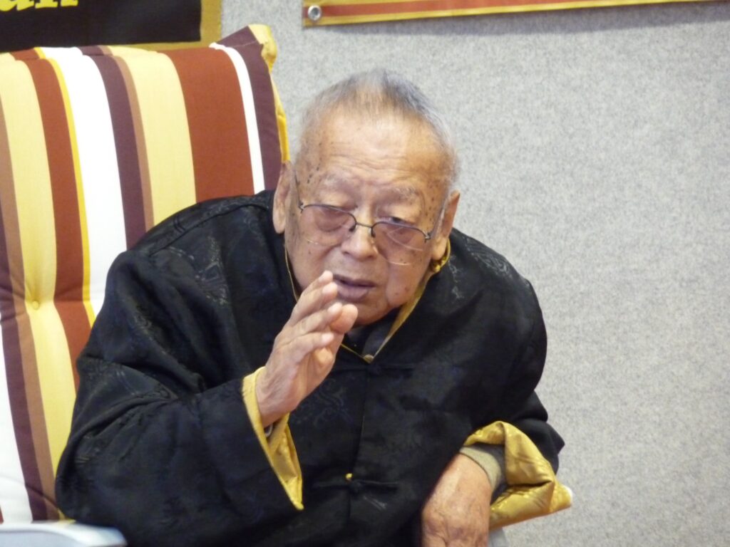 Wang Kiu geeft uitleg tijdens een seminar